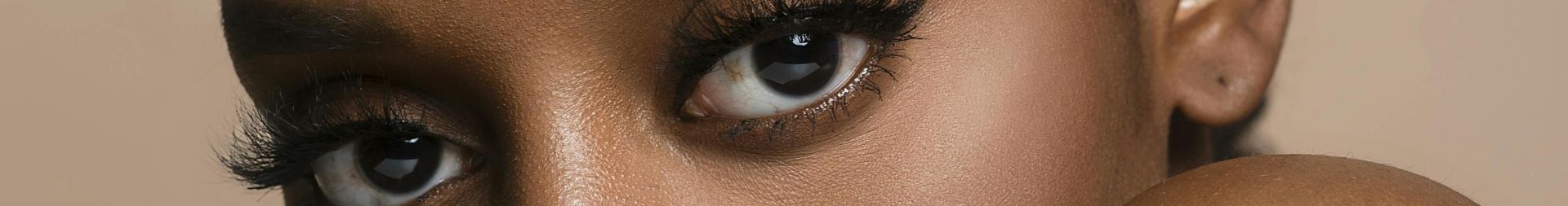 Stunning close-up portrait of a black woman with expressive eyes in a studio setting.