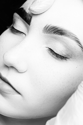 Intimate black and white portrait capturing the serene beauty of a woman in deep thought.